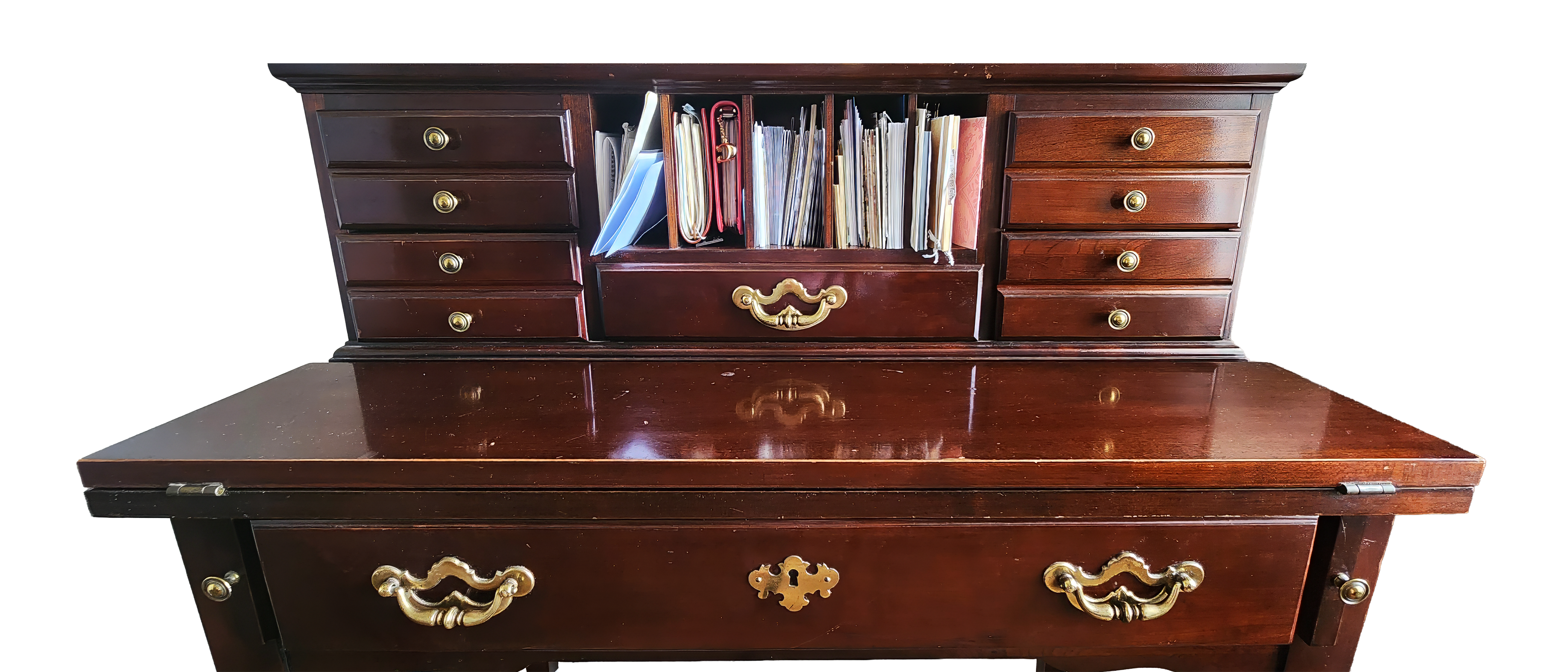 Vintage cherry wood writing desk with brass hardware, open compartments filled with journals, envelopes, and handmade stationery.